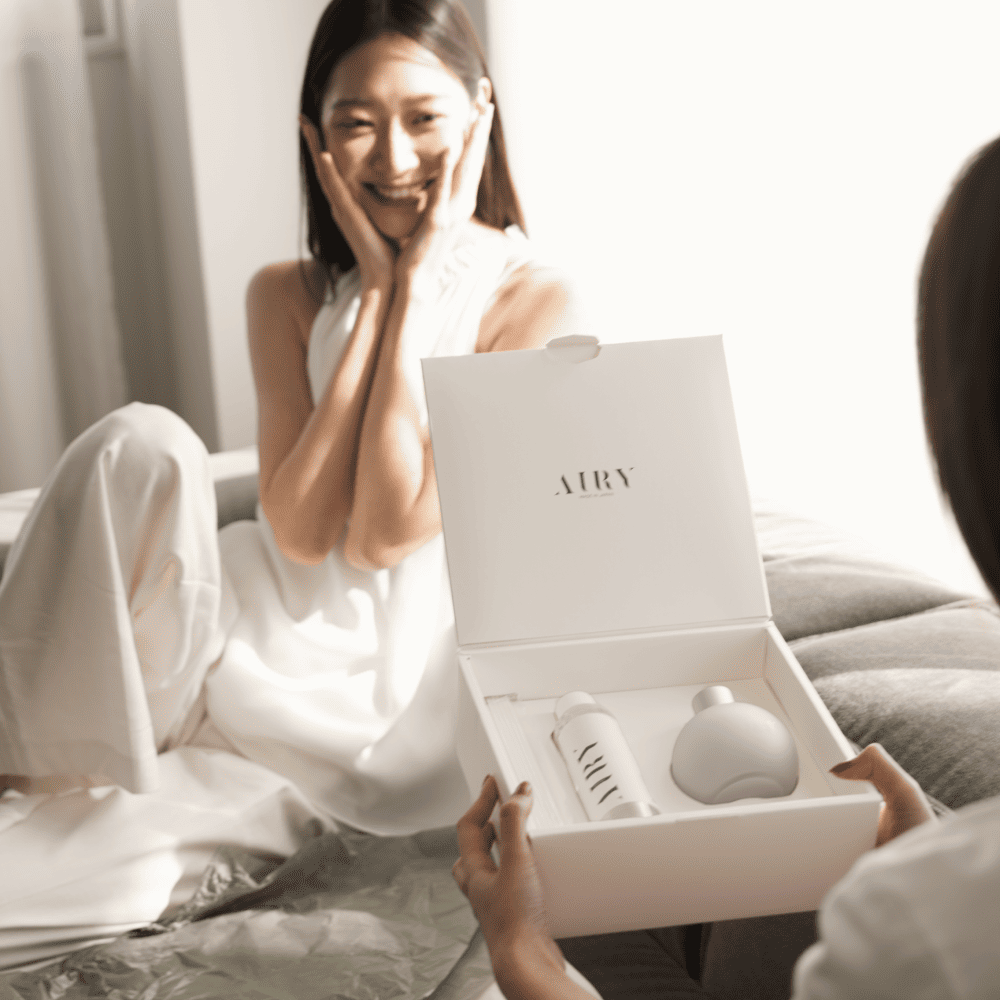 Luxury gift unboxing experience of the Elegant Harmony 優 reed diffuser set. The open premium white gift box reveals the frosted glass vessel and Kyoto Osmanthus fragrance oil refill, presented as a sophisticated gift for refined British homes.