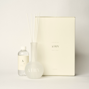 Mystic Essence 空 luxury reed diffuser set inspired by Tokyo’s Meguro River cherry blossoms. The image displays the signature 250ml artisan fragrance oil with notes of Sakura and Lychee, the frosted glass vessel, and premium white reeds against a minimalist background. A high-end Japanese gift for airy bedrooms and sunlit lounges.