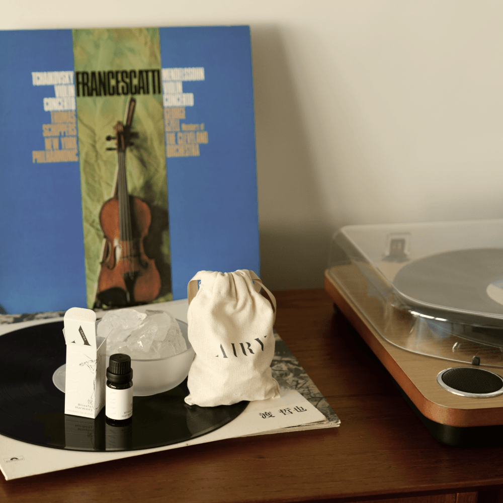 Airy Fragrances Stone Diffuser and Blissful Harmony 悅 (Etsu) fragrant oil styled on a wooden sideboard next to a vintage record player and classical music vinyl. This lifestyle scene highlights the set as a sophisticated interior decor piece, perfect for creating an uplifting, creative atmosphere in a living room or music nook