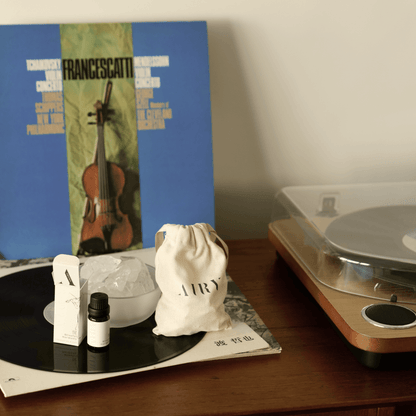 Airy Fragrances Stone Diffuser and Blissful Harmony 悅 (Etsu) fragrant oil styled on a wooden sideboard next to a vintage record player and classical music vinyl. This lifestyle scene highlights the set as a sophisticated interior decor piece, perfect for creating an uplifting, creative atmosphere in a living room or music nook