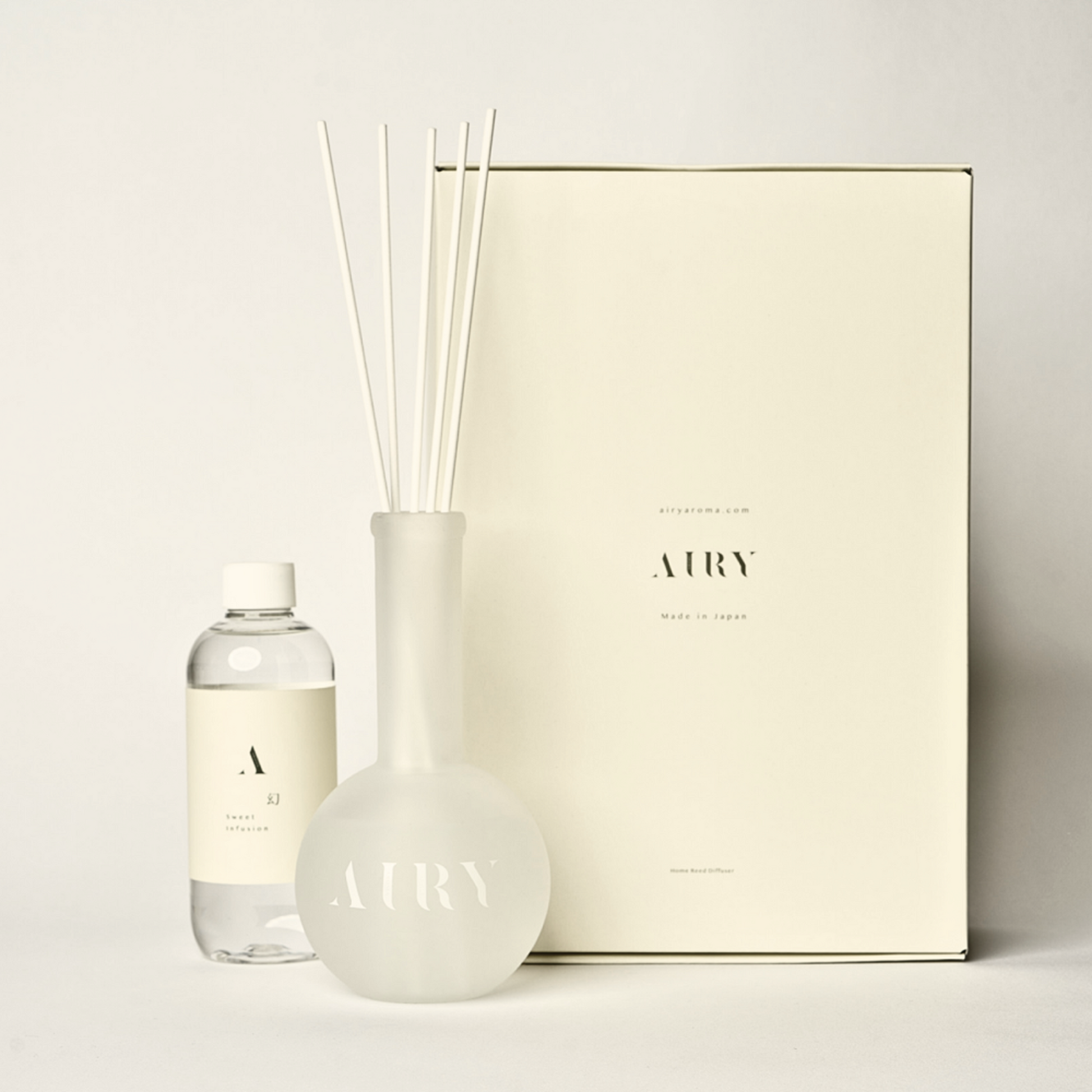 Sweet Infusion 幻 luxury reed diffuser set featuring Hakone Jin Xuan Tea and Magnolia. The 250ml artisan-crafted fragrance oil, frosted glass vessel, and premium white reeds are displayed with the signature Japanese gift box. A sophisticated, alcohol-free scent choice for high-end kitchens and living spaces.