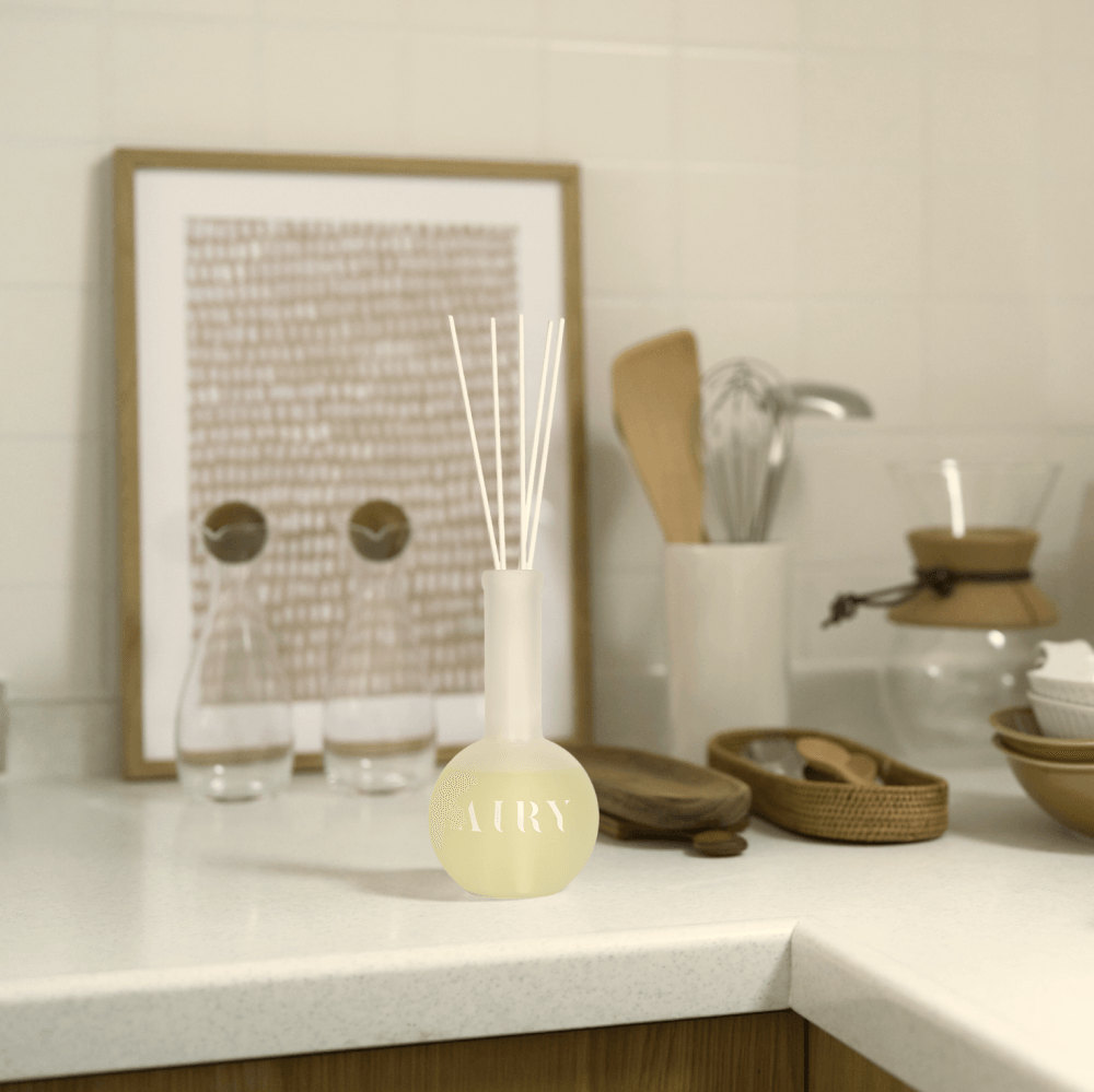 Forest Breath 森 reed diffuser displayed in a modern minimalist kitchen setting. The frosted glass vessel and white fiber reeds complement the clean, natural wood and stone textures, highlighting the Hinoki scent’s ability to refresh and clear the air in sophisticated culinary spaces.